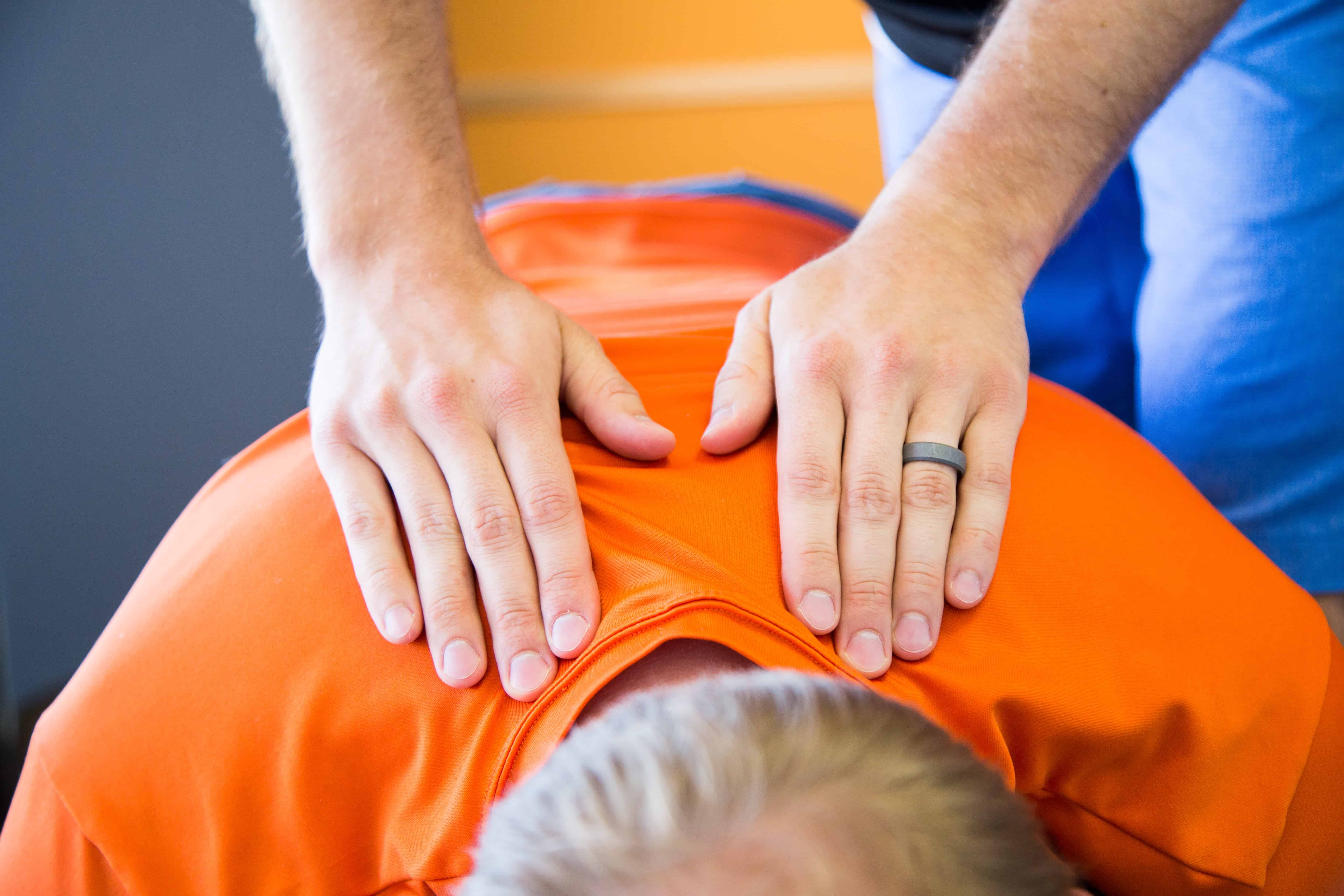 Chiropractor's hands palpating spine